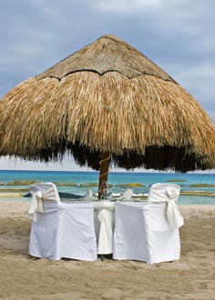 Decorated luxury dining table for two under beach umbrella