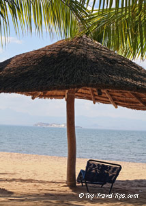 Travel weather - sunny beach Beach chair under sun umbrella in Zanzibar Tanzania