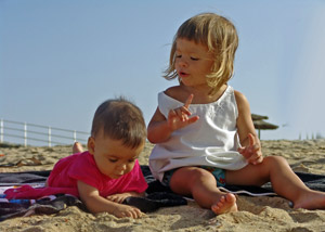 Travel packing checklist - young children playing Two kids playing on a beach